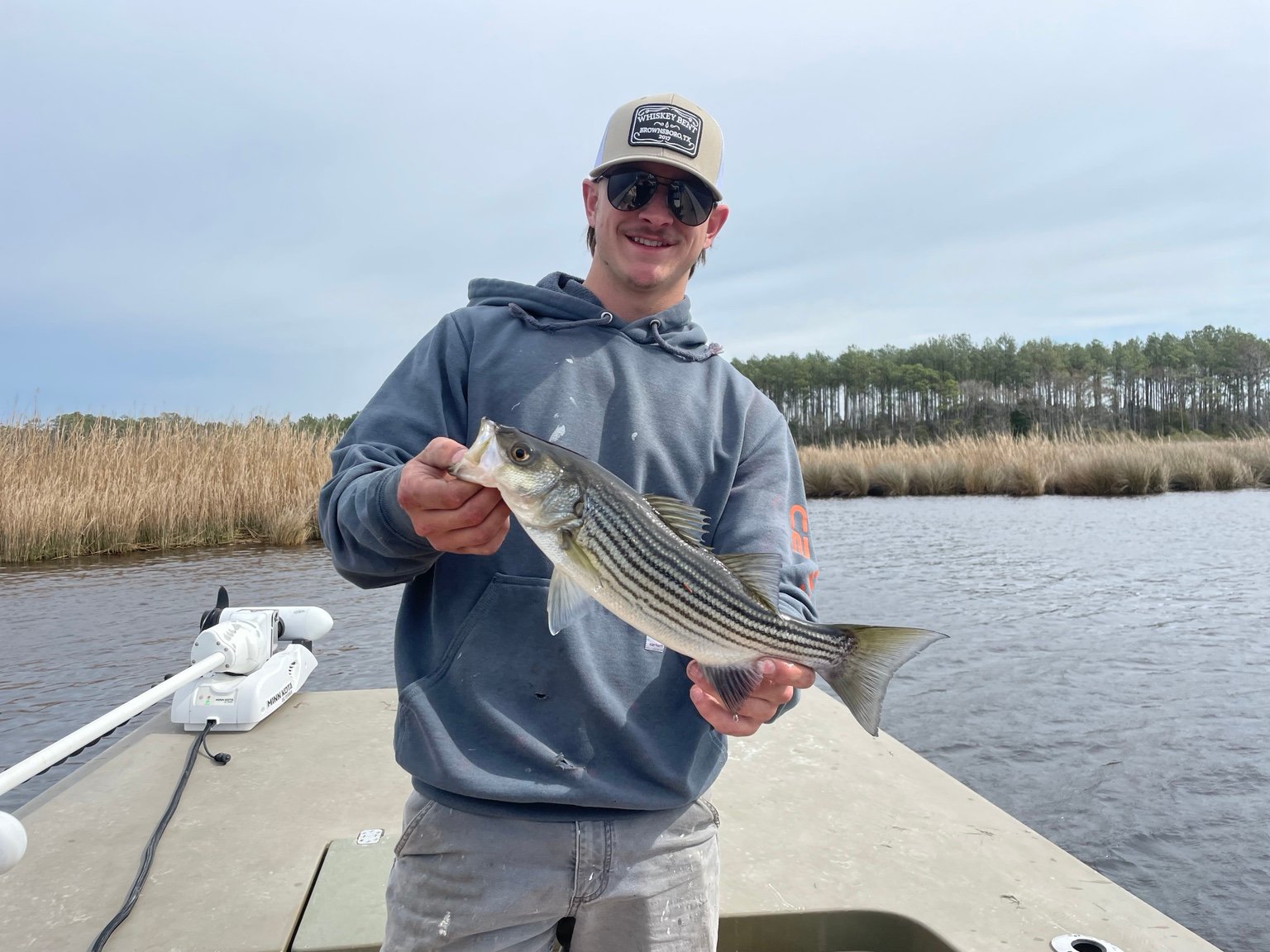 Angler holding a striped fish