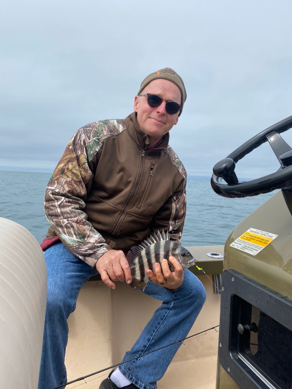 Angler holding a striped fish on a boat